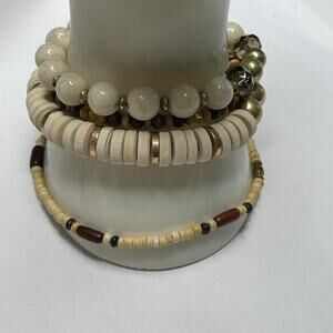 set of three bracelets gold tone and neutral natural stretch style as shown